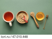 Чашка горячего гречишного чая и миска с мёдом на зелёном фоне. Стоковое фото, фотограф Pixel_shot / Фотобанк Лори