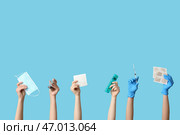 Женские руки с горчичниками, коробочкой для таблеток, ингалятором, медицинской маской и шприцем на синем фоне. Стоковое фото, фотограф Pixel_shot / Фотобанк Лори