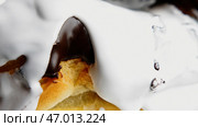 Large juicy chocolate eclairs that are poured with sugar white cream and removed close. Стоковое фото, фотограф David Kashakhi / Фотобанк Лори