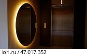 Interior of the lobby with elevator, toilets and glowing mirror. Стоковое фото, фотограф David Kashakhi / Фотобанк Лори