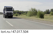 Truck transporting goods on the background of green field with bushes. Редакционная иллюстрация, иллюстратор David Kashakhi / Фотобанк Лори