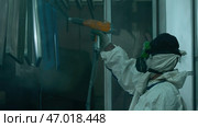 Worker coating metal sheets by anti corrosion powder substance. Стоковое фото, фотограф David Kashakhi / Фотобанк Лори