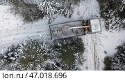 Aerial top view of a crane truck trying to turn around on narrow winter road. Стоковое фото, фотограф David Kashakhi / Фотобанк Лори