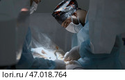 Male surgeon in mask and cap doing a blepharoplasty with medical tool. Стоковое фото, фотограф David Kashakhi / Фотобанк Лори