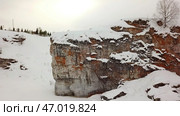 A Beautiful Snow Covered Cliff in a Picturesque Winter Landscape for Outdoor Adventure Exploration. Стоковое фото, фотограф David Kashakhi / Фотобанк Лори