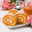 Sliced pumpkin and carrot roll with cream filling with a cup of green tea and a bouquet of pink alstroemeria. Стоковое фото, фотограф Неведицына Елена / Фотобанк Лори