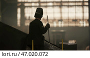 A Mysterious Figure Stands Amid an Industrial Setting as Dusk Begins to Fall All Around. Стоковое фото, фотограф David Kashakhi / Фотобанк Лори