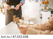 Бариста приносит горячий эспрессо посетителю в кафе. Стоковое фото, фотограф Pixel_shot / Фотобанк Лори