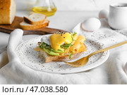 Вкусный бутерброд с флорентийским яйцом, сыром и авокадо на светлом фоне. Стоковое фото, фотограф Pixel_shot / Фотобанк Лори