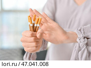 Молодая беременная женщина, отвергая сигареты, крупным планом. Концепция отказа от вредной привычки. Стоковое фото, фотограф Pixel_shot / Фотобанк Лори