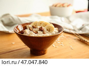 Чаша со вкусной сладкой овсяной кашей на деревянном столе. Стоковое фото, фотограф Pixel_shot / Фотобанк Лори