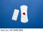Менструальная прокладка с красными блестками и таблетки на цветном фоне. Стоковое фото, фотограф Pixel_shot / Фотобанк Лори