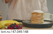 Delicious pile of pancakes is covered with sweet powdered sugar during cooking process, following homemade recipe in kitchen. Стоковое видео, видеограф Strunov David / Фотобанк Лори