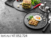 Тарелка с вкусной кабачковой вафлей и жареным яйцом на темном столе. Стоковое фото, фотограф Pixel_shot / Фотобанк Лори