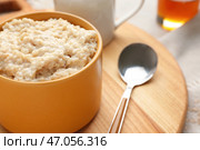 Чаша с вкусной овсяной кашей на деревянной доске, крупным планом. Стоковое фото, фотограф Pixel_shot / Фотобанк Лори