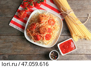 Тарелка вкусных макарон с мясом и томатным соусом на деревянном столе. Стоковое фото, фотограф Pixel_shot / Фотобанк Лори