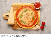 Деревянная доска со вкусной пиццей с пармезаном и томатным соусом на сером граните. Стоковое фото, фотограф Pixel_shot / Фотобанк Лори