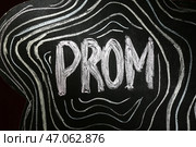 Доска с написанным словом PROM на темном фоне, крупный план. Стоковое фото, фотограф Pixel_shot / Фотобанк Лори
