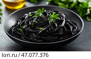 A bowl of inky squid ink pasta, garnished with minimal parsley leaves. Высококачественная фотография миски чернильной пасты с кальмарами, гарнированной минимальным количеством листьев петрушки и капелькой оливкового масла, поставленной на матовый черный стол для эффектной презентации. Стоковое AI-изображение, AI-художник Katsiaryna Repich / Фотобанк Лори