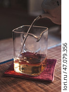 An Elegant and Refined Pour of Rich Whiskey into a Glass, Resting on a Colorful Coaster. Стоковое фото, фотограф David Kashakhi / Фотобанк Лори