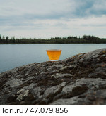 A calming and tranquil waterside scene featuring a refreshing beverage in the heart of nature. Стоковое фото, фотограф David Kashakhi / Фотобанк Лори