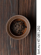 A Bowl Filled with Dried Black Tea Leaves Placed on a Rustic Wooden Table Surface. Стоковое фото, фотограф David Kashakhi / Фотобанк Лори