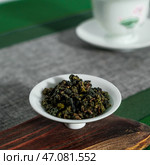A closeup view of Oolong tea leaves is thoughtfully and beautifully arranged within a lovely bowl. Стоковое фото, фотограф David Kashakhi / Фотобанк Лори