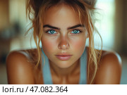 Portrait of a young woman with expressive blue eyes and fair tanned skin. Her natural beauty is emphasized by minimal makeup and slightly disheveled light brown hair. The atmosphere of the frame is warm and soft, the lighting creates a cozy, natural effect. The girl's gaze is intent, confident, and seems to penetrate the soul. The background is blurred, which focuses attention on her face. Стоковое AI-изображение, AI-художник Анна Кривицкая / Фотобанк Лори