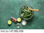 Стеклянная миска со свежими листьями капусты кейл и различными специями на зеленом фоне. Стоковое фото, фотограф Pixel_shot / Фотобанк Лори
