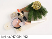 Красивый композиционный натюрморт с декоративной косметикой, мраморным подносом, веткой ели и рождественскими шарами на белом фоне. Стоковое фото, фотограф Pixel_shot / Фотобанк Лори
