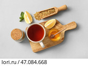 Чашка горячего гречишного чая с лимоном, мятой и миской мёда на сером фоне. Стоковое фото, фотограф Pixel_shot / Фотобанк Лори