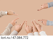 Множество рук, указывающих на что-то на бежевом фоне. Стоковое фото, фотограф Pixel_shot / Фотобанк Лори
