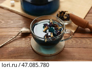 Чашка с чаем из цветков клитории и бамбуковый коврик на деревянном фоне, крупный план. Стоковое фото, фотограф Pixel_shot / Фотобанк Лори