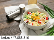 Миска салата с крабовыми палочками, кукурузой и огурцом на деревянном фоне. Стоковое фото, фотограф Pixel_shot / Фотобанк Лори