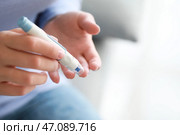 Диабетическая женщина, берущая образец крови с помощью ланцетной ручки, крупным планом. Стоковое фото, фотограф Pixel_shot / Фотобанк Лори