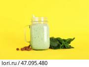 Банка с крышкой, наполненная свежим шпинатным смузи с миндальными орехами на желтом фоне. Стоковое фото, фотограф Pixel_shot / Фотобанк Лори