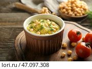Чаша с вкусным хумусом на деревянной доске, крупным планом. Стоковое фото, фотограф Pixel_shot / Фотобанк Лори