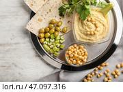Чаши с вкусным хумусом, нутом и лепешкой на металлическом подносе. Стоковое фото, фотограф Pixel_shot / Фотобанк Лори