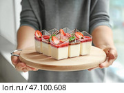 Женщина держит деревянную доску с вкусной шоколадной панна коттой в очках, крупным планом. Стоковое фото, фотограф Pixel_shot / Фотобанк Лори