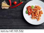 Тарелка с вкусной пастой пенне и соусом Болоньезе на деревянном столе. Стоковое фото, фотограф Pixel_shot / Фотобанк Лори