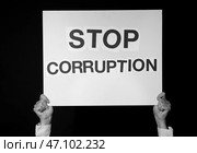 Женщина держит плакат с текстом ОСТАНОВИТЬ КОРРУПЦИЮ на темном фоне, черно-белый эффект. Стоковое фото, фотограф Pixel_shot / Фотобанк Лори