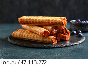 Грифельная доска из вафельных трубочек с вареным сгущенным молоком на сером гранж-столе. Стоковое фото, фотограф Pixel_shot / Фотобанк Лори