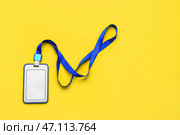 Пустой бейдж с синим шнурком на желтом фоне. Стоковое фото, фотограф Pixel_shot / Фотобанк Лори