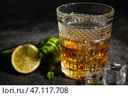 Стакан рома со льдом, мятой и лаймом на темном столе. Стоковое фото, фотограф Pixel_shot / Фотобанк Лори