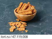 Чаша вкусных кунжутных козинаки на синем фоне. Стоковое фото, фотограф Pixel_shot / Фотобанк Лори