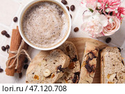 Доска с вкусным печеньем бискотти, чашкой кофе, цветами и бобами на фоне плитки. Стоковое фото, фотограф Pixel_shot / Фотобанк Лори