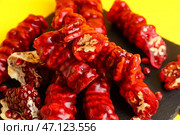 Сланцевая доска с вкусным чурчхела и гранатом на желтом фоне, крупный план. Стоковое фото, фотограф Pixel_shot / Фотобанк Лори