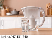 Фильтрующий кувшин и стакан воды на столе на кухне. Стоковое фото, фотограф Pixel_shot / Фотобанк Лори