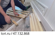 A man assembles the base of a couch. He fastens wooden slats with screws. Стоковое видео, видеограф Vadzim Yakubovich / Фотобанк Лори