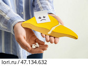 Женщина с грустным лицом держит желтую бумажную печень с таблетками на белом фоне. Стоковое фото, фотограф Pixel_shot / Фотобанк Лори